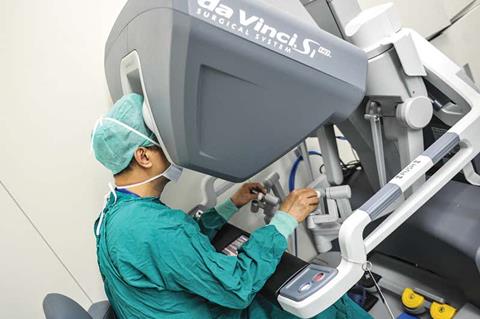 Surgeons operate robots from a remote console